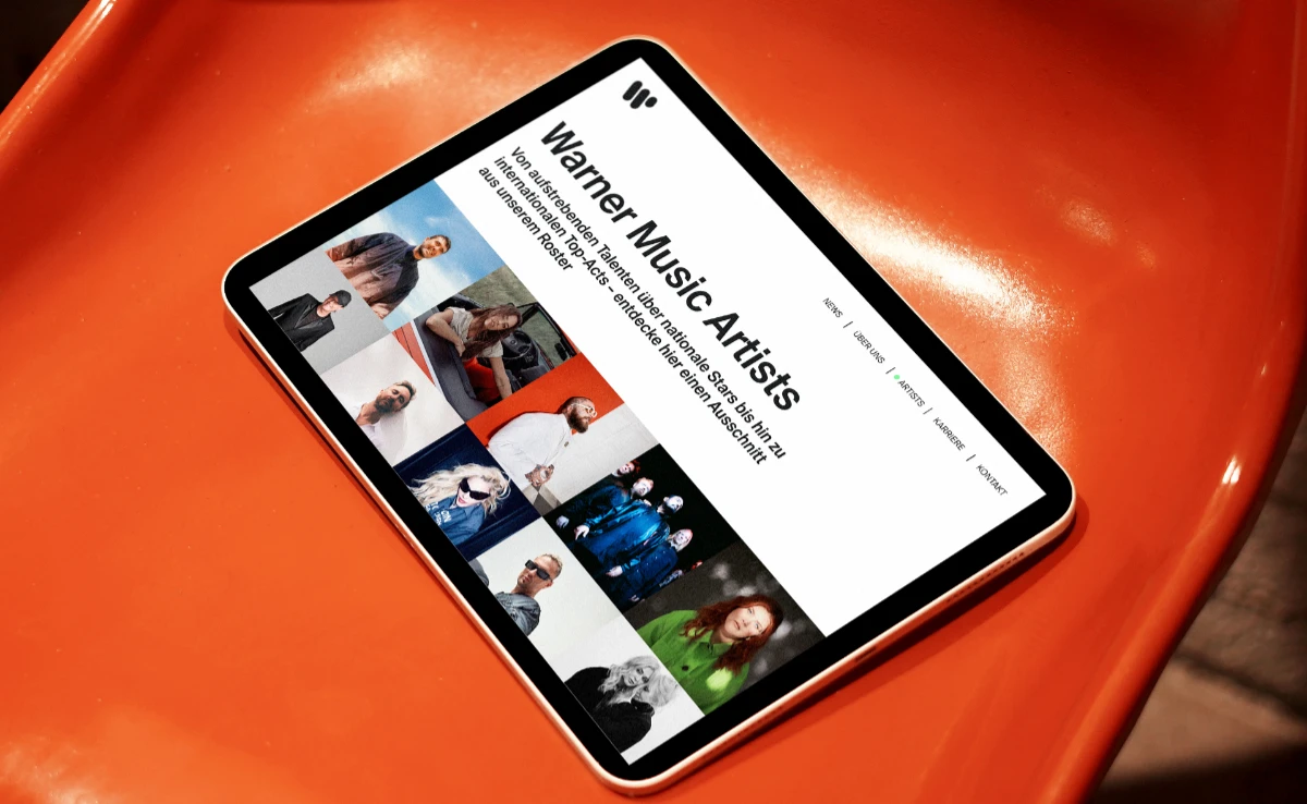 Website Warner Music Germany: Artists Seite auf Tablet auf orangem Plastikstuhl