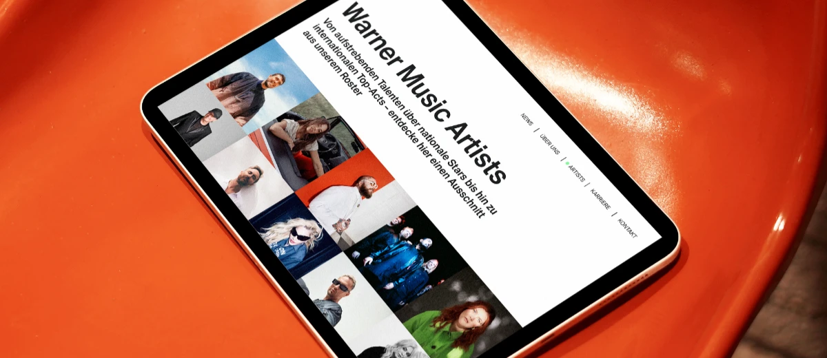 Website Warner Music Germany: Artists Seite auf Tablet auf orangem Plastikstuhl