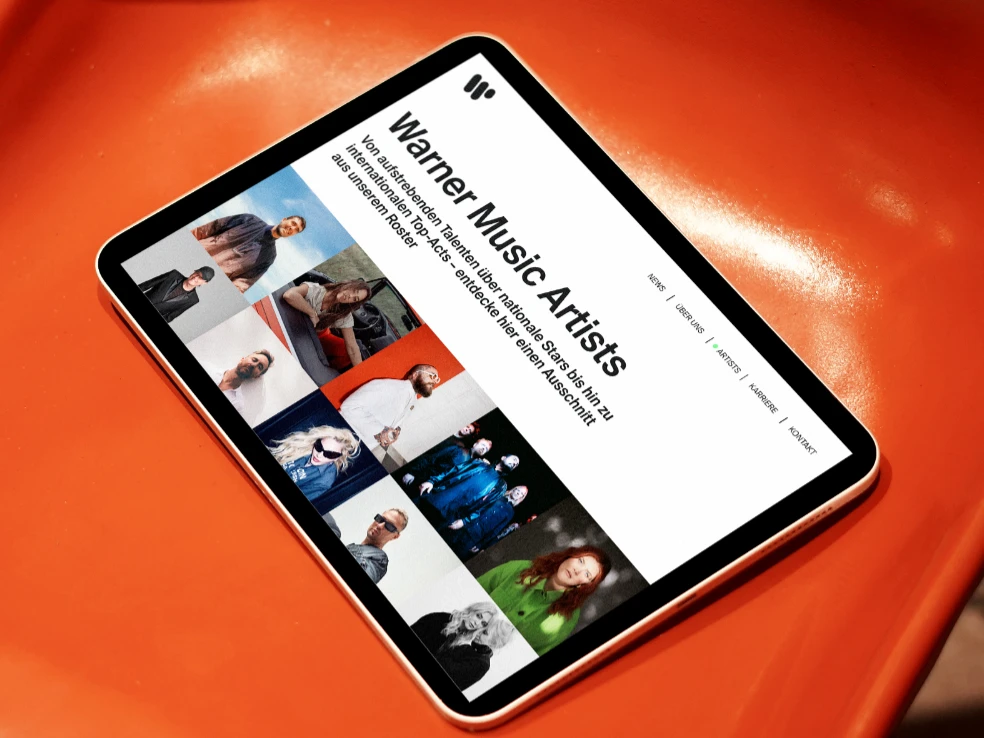 Website Warner Music Germany: Artists Seite auf Tablet auf orangem Plastikstuhl