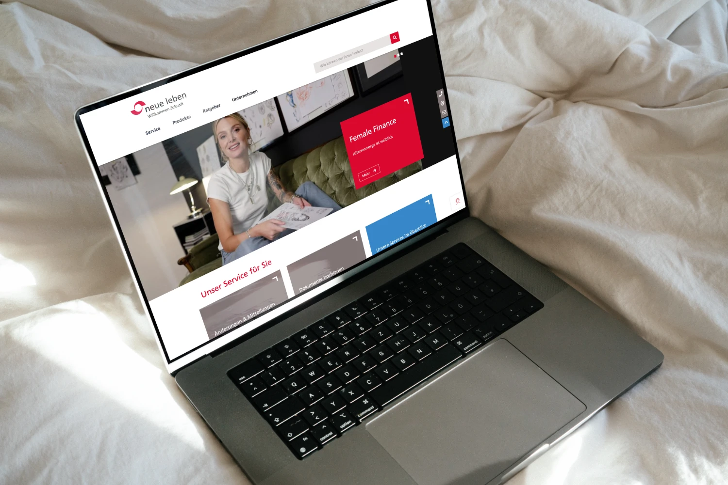 Laptop auf Bettzeug: Startseite des neue leben Partnerportals geöffnet auf Bildschirm